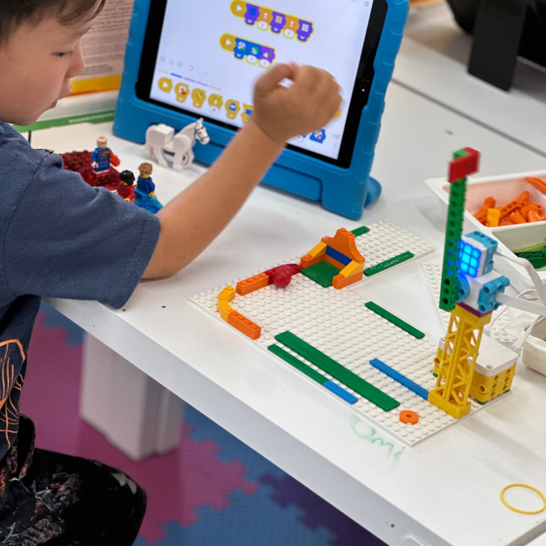 niño observando detalles de armado y programación en tablet de lego spike essemtial education
